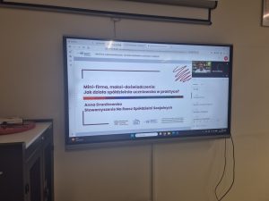 Monitor interaktywny z prezentacją „Mini-firma, maksi-doświadczenie: Jak działa spółdzielnia uczniowska w praktyce?”, prowadzoną przez Annę Dranikowską.