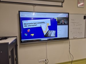 Monitor interaktywny wyświetlający prezentację „Ekonomia jest wszędzie. Nie wierzycie?” podczas lekcji online w ramach projektu BAKCYL.