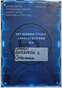 Pamiątkowy akt nadania tytułu „Łamaczy Szyfrów” dla „Gangu Świeżaków z Ostaszewa”, otrzymany podczas warsztatów w Centrum Nauki Experyment.