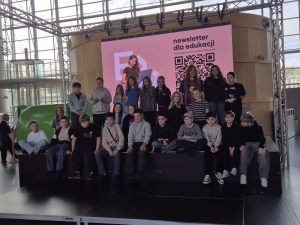 Uczniowie klas V–VI pozują do wspólnego zdjęcia na scenie w przestronnym holu Centrum Nauki Experyment w Gdyni.